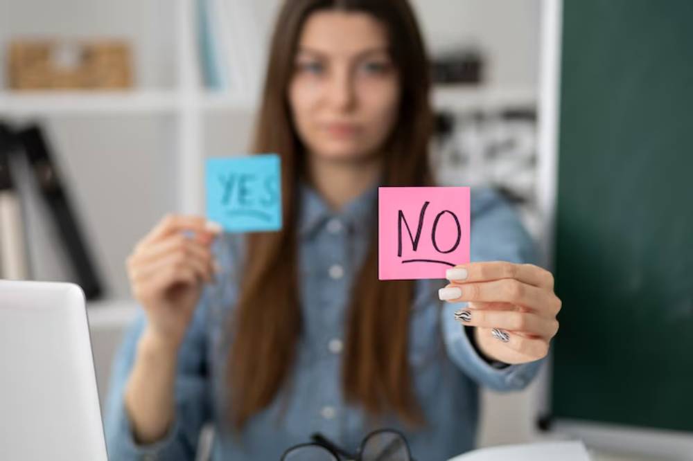 A person holding a blue sticky note labeled 'YES' in one hand and a pink sticky note labeled 'NO' in the other.