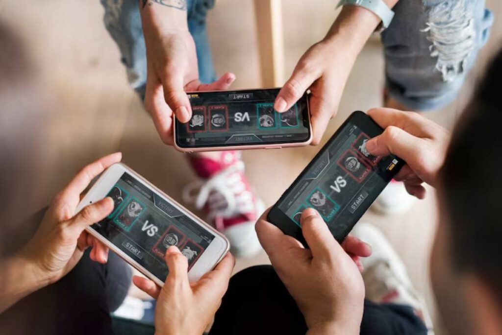 Four hands holding smartphones displaying a competitive mobile game screen showing "VS" and character selections.