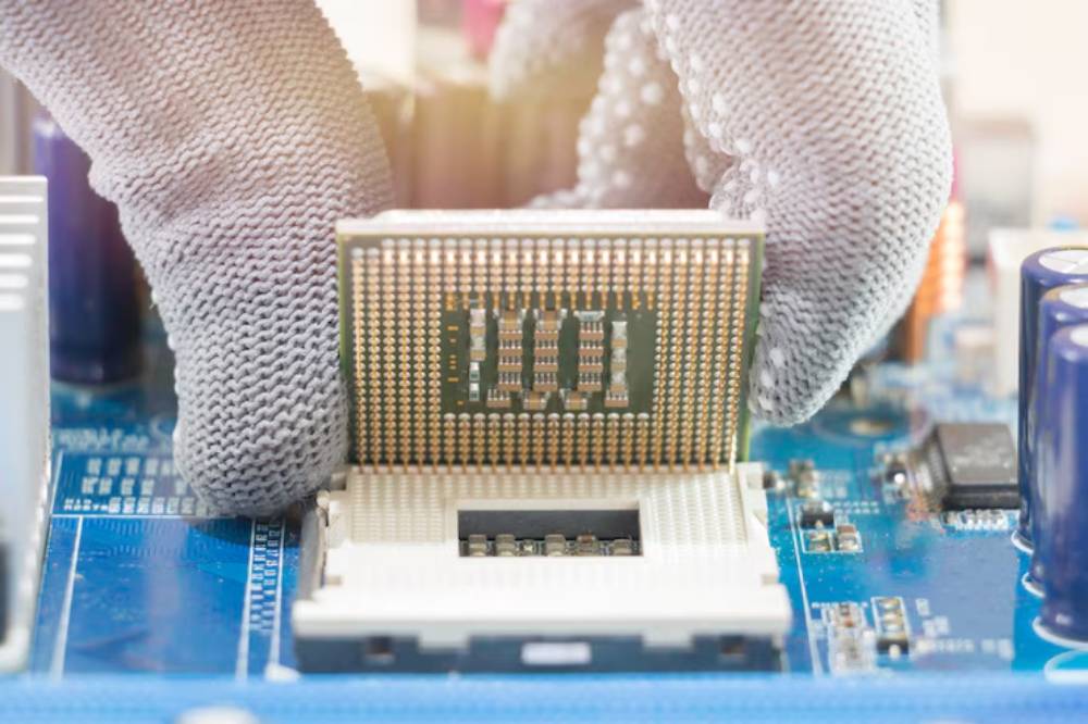 A gloved hand carefully places a CPU onto a motherboard, showcasing intricate circuitry and components in the background.