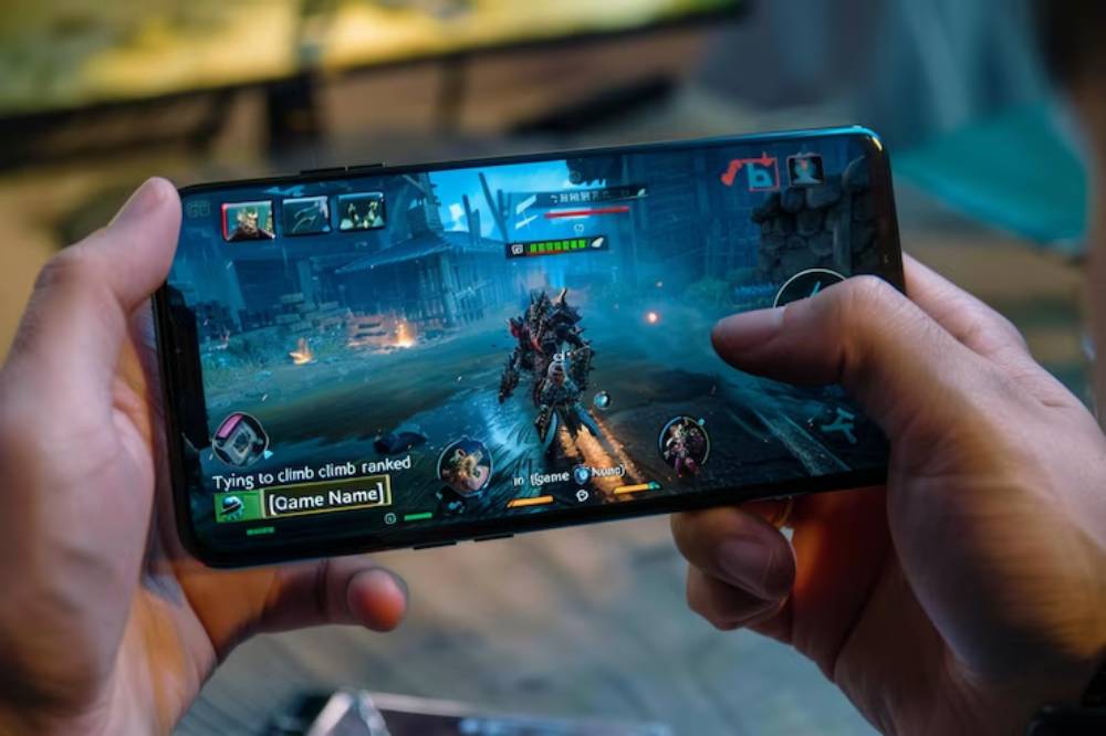 A close-up of hands holding a smartphone displaying a gaming interface with characters battling in a fantasy setting.