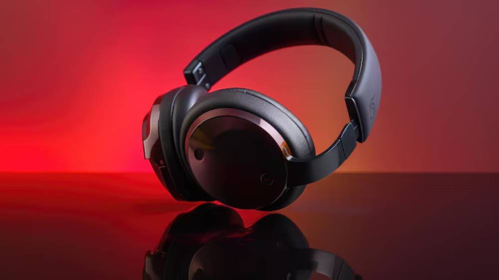 Stylish black gaming headphones positioned artistically against a warm red gradient background, reflecting off a shiny surface.